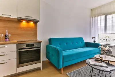 a living room with a blue couch and a table at Royal Residence Apartment in Budva