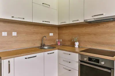 a kitchen with white cabinets and a sink at Royal Residence Apartment in Budva