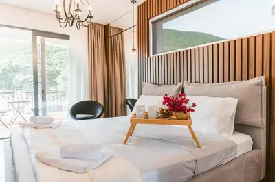 a bedroom with a bed with a table with flowers on it at Carolea Villas - Boutique Hotel & Villas in Ulcinj