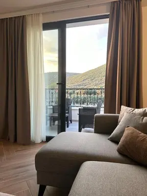 a living room with a couch and a large window at Carolea Villas - Boutique Hotel & Villas in Ulcinj