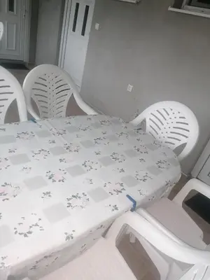 a white table and four white chairs with a white table and chairsktop at Apartmani Momčilović in Čanj