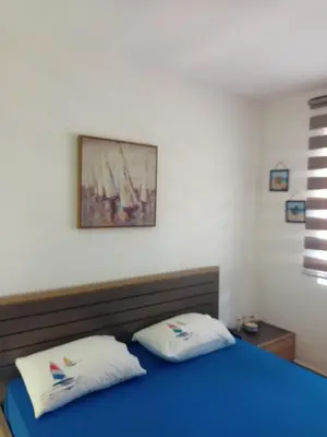 a bedroom with a blue bed with two white pillows at Anika in Sutomore