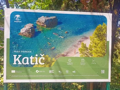 a sign for a beach with rocks in the water at Anika in Sutomore