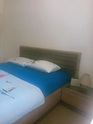 a bedroom with a bed with a headboard and a lamp at Anika in Sutomore