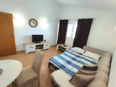 a living room with a couch and a bed at Apartmani Durovic in Bar