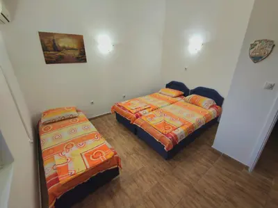 a room with two beds and a bedskirts at Apartmani Durovic in Bar