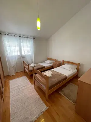 a bedroom with two beds and two rugs at Aquarium Apartment Kotor in Kotor