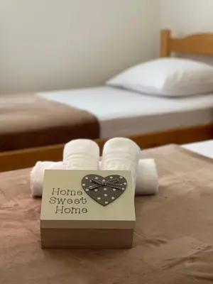 a box of towels on a bed with a sign at Aquarium Apartment Kotor in Kotor