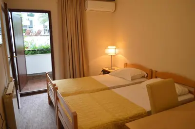 a hotel room with two beds and a balcony at Ambassador Apartments in Petrovac na Moru