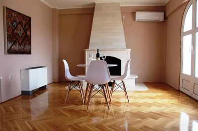 a dining room with a table and white chairs at Hotel Crnogorska Kuća in Podgorica