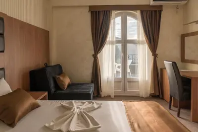a hotel room with a bed and a window at Hotel Crnogorska Kuća in Podgorica