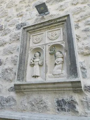 a stone wall with two statues on a building at I&G APARTMENTS in Kotor