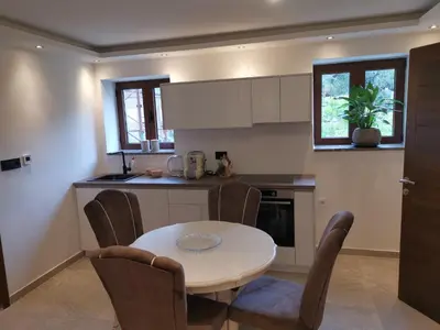 a kitchen with a table and chairs in a kitchen at I&G APARTMENTS in Kotor