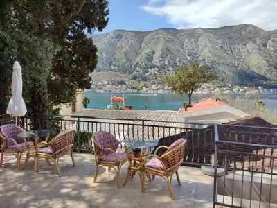 a patio with a table and chairs and a view of the water at Bay Mola Aparts in Kotor