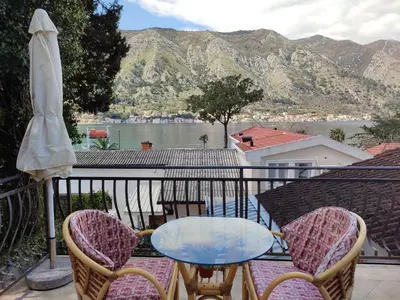 a table and chairs on a balcony with a view of the water at Bay Mola Aparts in Kotor