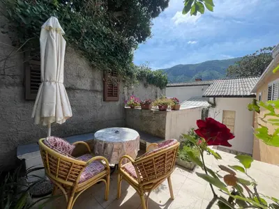 a patio with a table and chairs and an umbrella at Bay Mola Aparts in Kotor