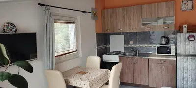a small kitchen with a table and chairs in a room at Bay Mola Aparts in Kotor