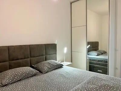 a bedroom with a large bed and a mirror at Kaljevic 13 in Bar