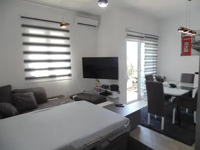 a living room with a bed and a table and a television at Kaljevic 13 in Bar