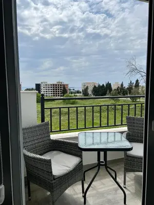 a balcony with a table and chairs and a view of a field at Kaljevic 13 in Bar