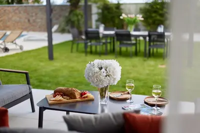 a table with a plate of food and glasses of wine at Villa Garden with Private Outdoor Pool in Kotor
