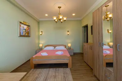 a bedroom with two beds and a chandelier at DreamSea Apartment in Utjeha