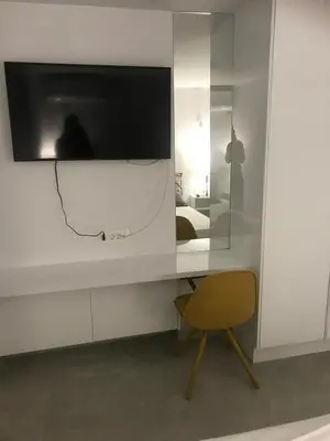 a room with a desk with a television and a chair at Lux Beach House M in Pržno