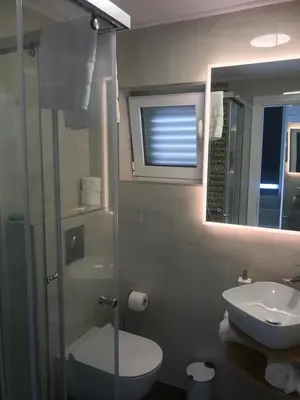 a bathroom with a sink and a toilet and a mirror at Lux Beach House M in Pržno