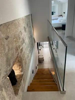 a staircase in a house with a stone wall at Lux Beach House M in Pržno