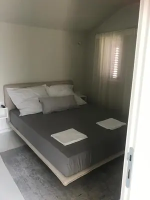 a large bed with white pillows and a window at Lux Beach House M in Pržno