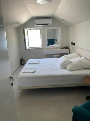 a bedroom with a large white bed and a mirror at Lux Beach House M in Pržno