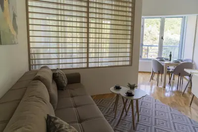 a living room with a couch and a table at Studio apartment Sunrise Rafailovici in Budva
