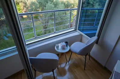two chairs and a table in front of a window at Studio apartment Sunrise Rafailovici in Budva