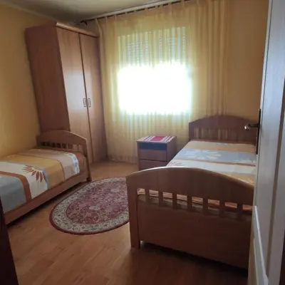a small bedroom with two beds and a window at Apartman Becici beach in Becici