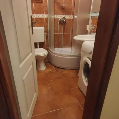 a bathroom with a shower toilet and a washing machine at Apartman Becici beach in Becici