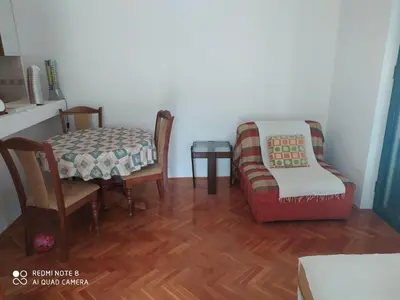 a living room with a table and chairs and a couch at Apartman Potkošljun in Budva