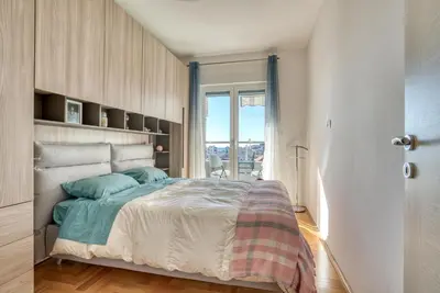 a bedroom with a large bed and a window at Baby Blue Apartments in Budva