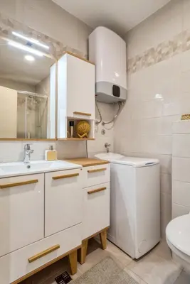 a white bathroom with a sink and a toilet at Baby Blue Apartments in Budva