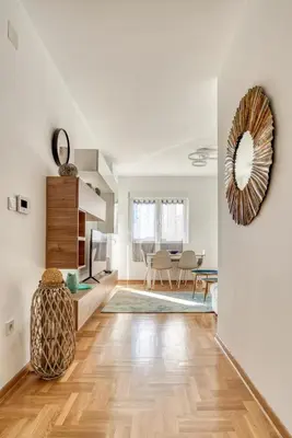a living room with white walls and a wooden floor at Baby Blue Apartments in Budva
