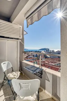 a balcony with two chairs and a view of a city at Baby Blue Apartments in Budva