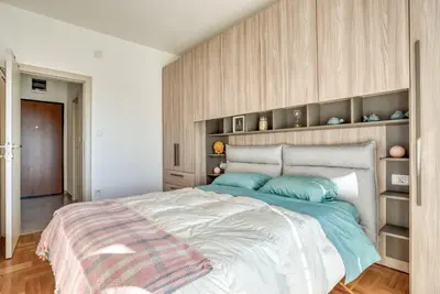 a bedroom with a large bed with blue pillows at Baby Blue Apartments in Budva
