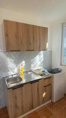 a kitchen with wooden cabinets and a sink at Extra lokacija!!!!! in Sutomore