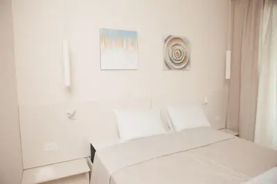 a white room with two beds and a window at Apartment MARIA Lux in Rafailovici