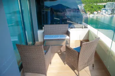 a balcony with chairs and a view of the water at Apartment MARIA Lux in Rafailovici