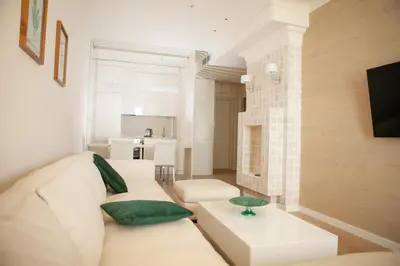 a living room with a white couch and a table at Apartment MARIA Lux in Rafailovici
