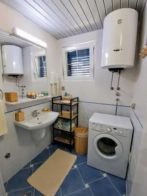 a bathroom with a washing machine and a sink at Apartman - Fontana (Rafailovici) in Rafailovici