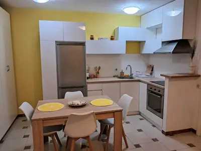 a small kitchen with a wooden table and chairs at Apartman - Fontana (Rafailovici) in Rafailovici