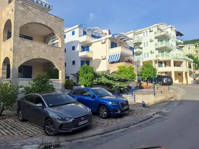 two cars parked on the side of a street at Apartman - Fontana (Rafailovici) in Rafailovici