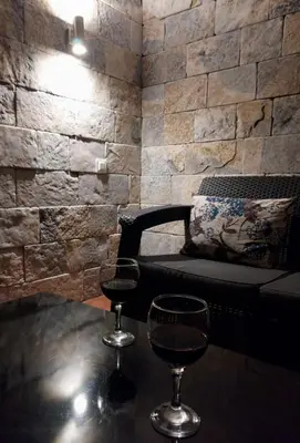 two glasses of wine sitting on a table with a chair at APARTMANI VUKADINOVIC LUX in Budva