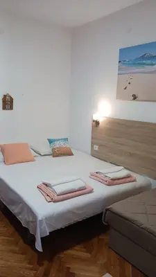 a bedroom with a white bed with towels on it at Studio Dina in Becici